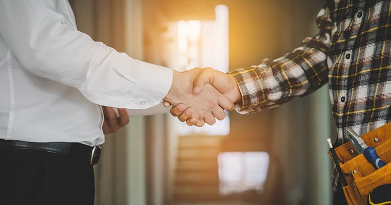 Appliance repair worker shaking hands with customer