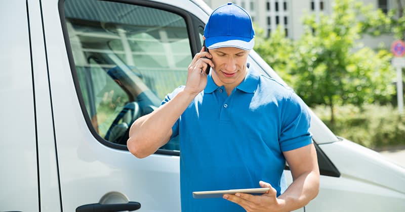 Man on phone in front of van